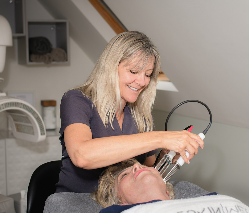 Julie Ward performing a CACI treatment on a client in her Olney clinic